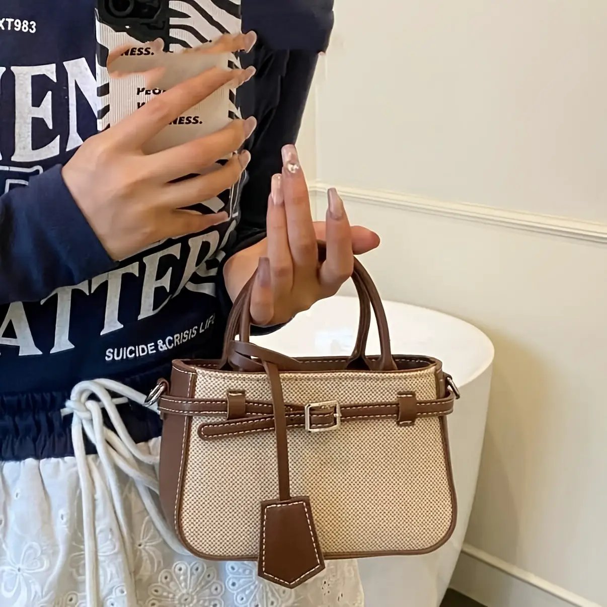 Commuter-friendly beige fabric crossbody tote with brown leather trim