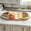 Acacia wood charcuterie tray with four triangular ceramic bowls.