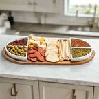 Acacia wood charcuterie tray with four triangular ceramic bowls.