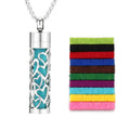 Scent Necklace pendant with teal filigree over turquoise panel on silver chain beside a stack of 10 felt bands.