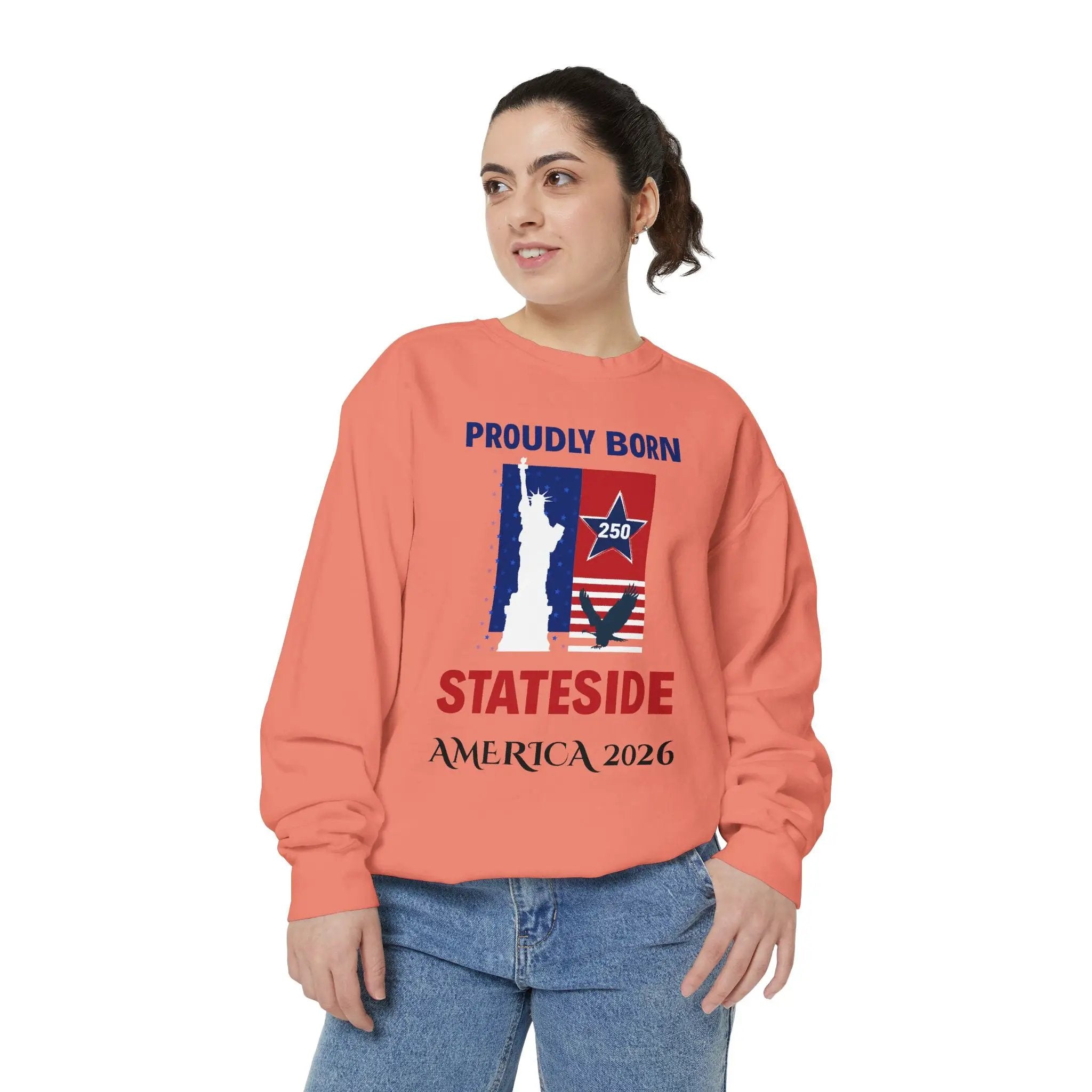 Peach crewneck sweatshirt with patriotic graphic showing Statue of Liberty and American flag, STATESIDE AMERICA 2026.
