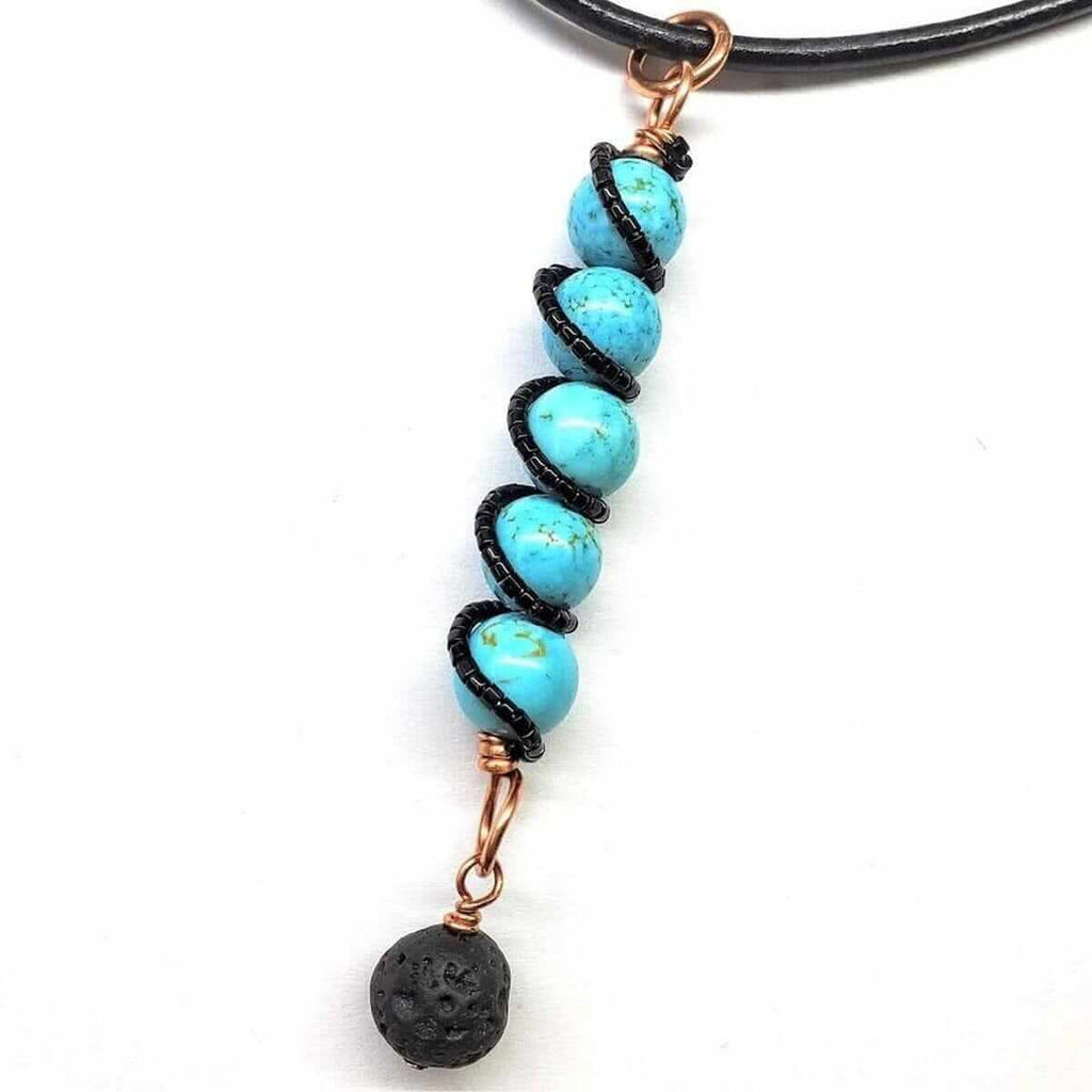 Necklace with turquoise beads wrapped in black wire and copper accents, lava rock charm at end