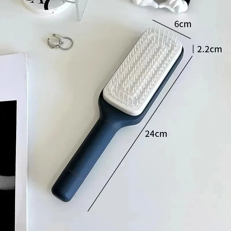 Rotating self-cleaning hairbrush with blue handle and white bristle plate, 24 cm long