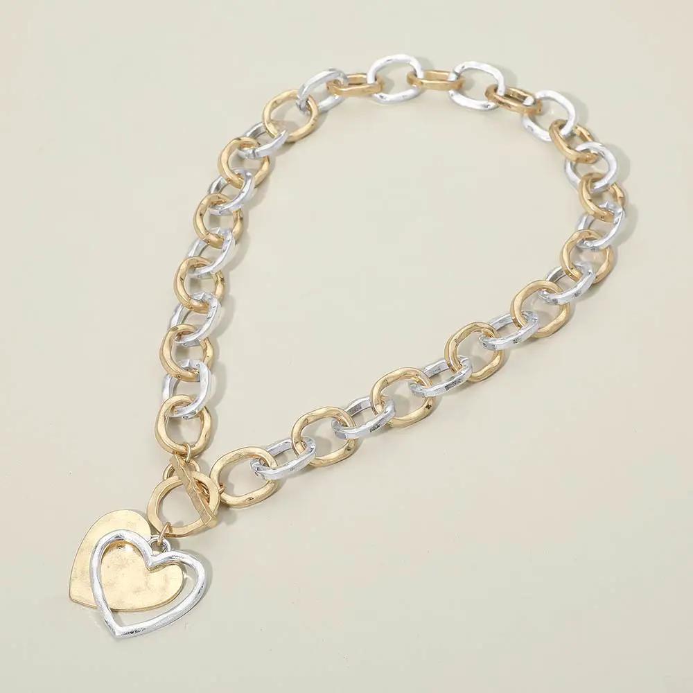 Hammered layered heart pendant necklace by Madeline Love on a gold and silver chunky chain