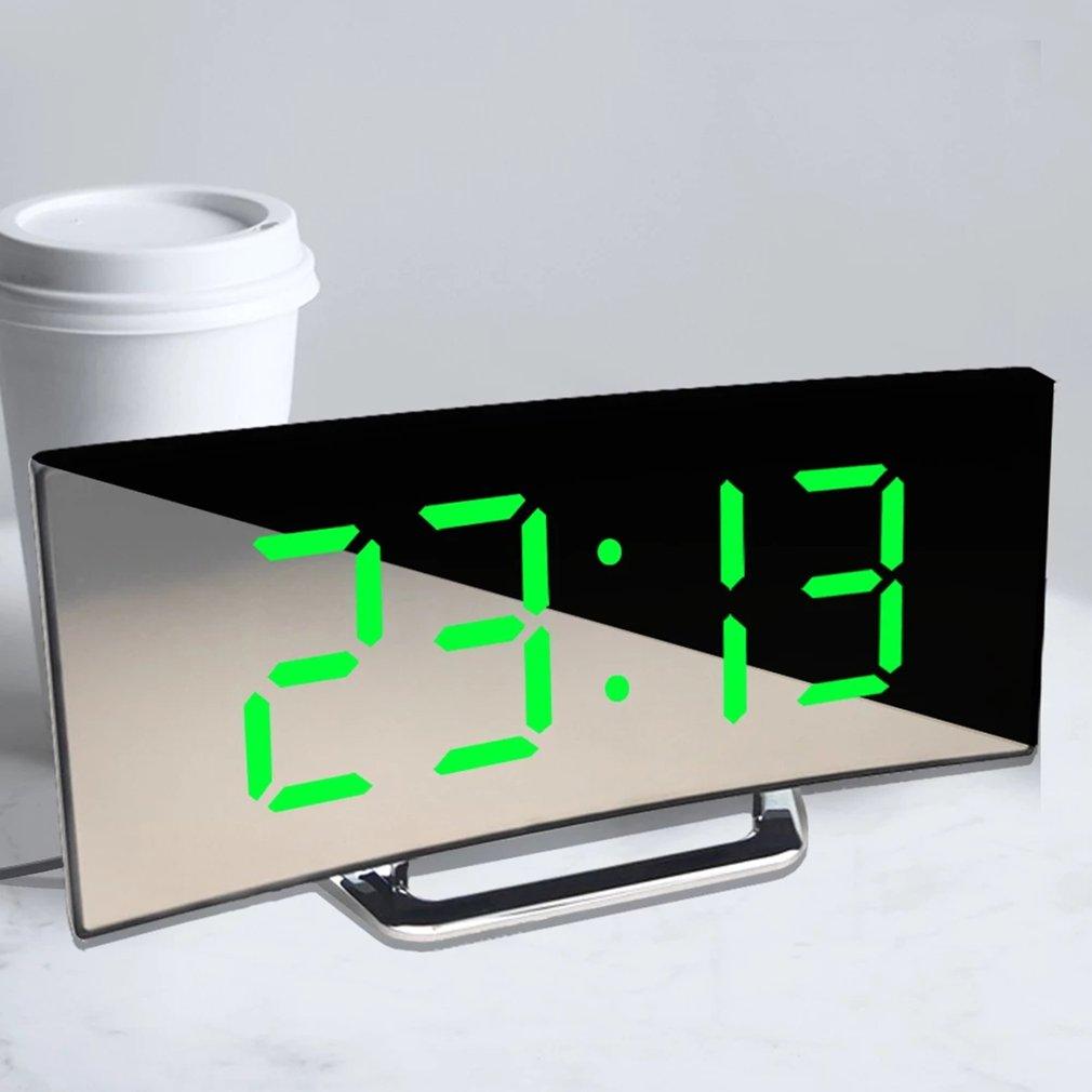 Stevvex digital alarm clock with large green LED digits on a mirrored curved surface.