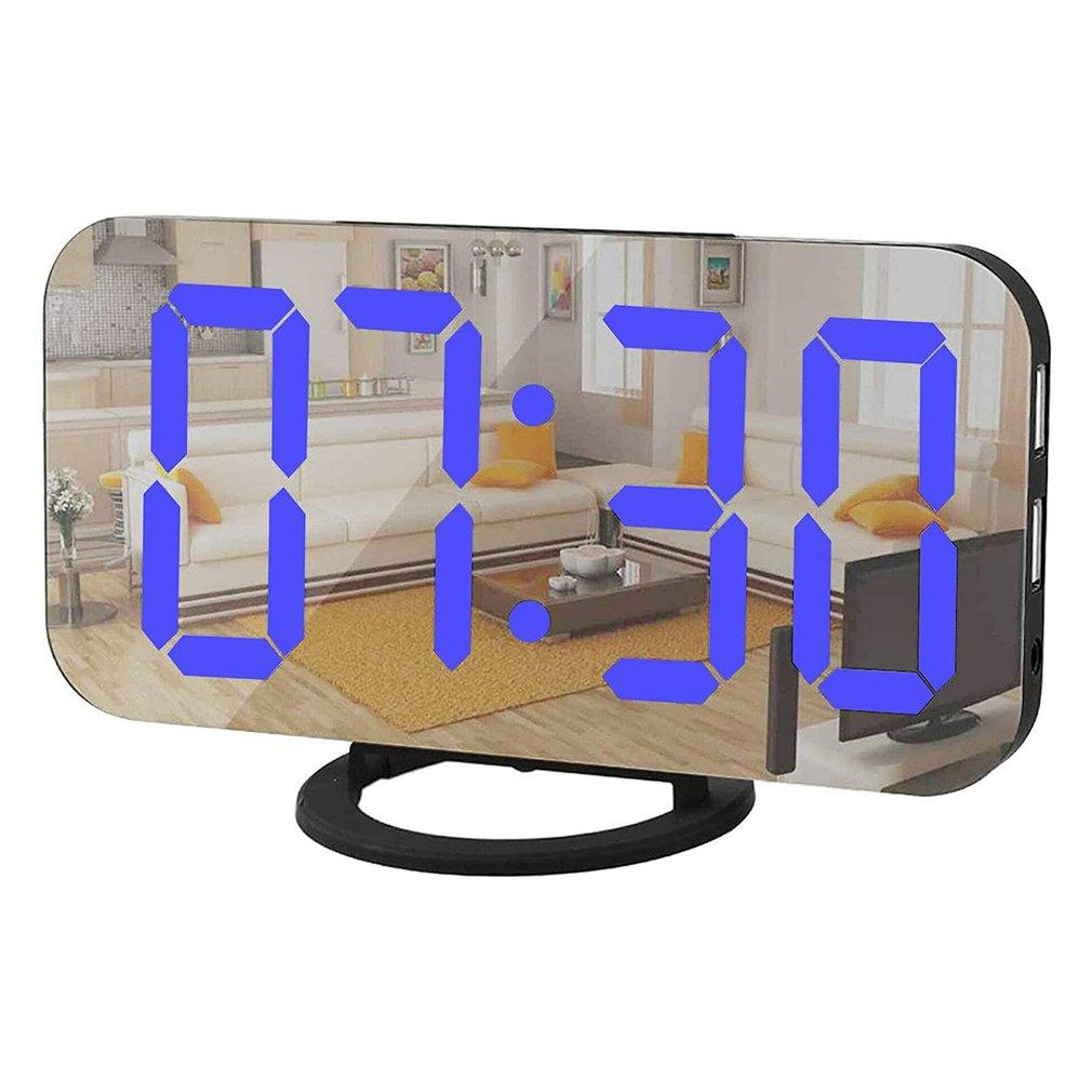 Digital alarm clock with large curved mirror surface, bright blue LED display, and dual USB ports.