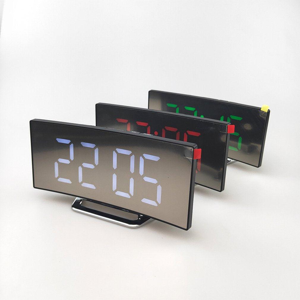 Set of three digital alarm clocks with large curved mirror LED displays showing blue, red and green digits