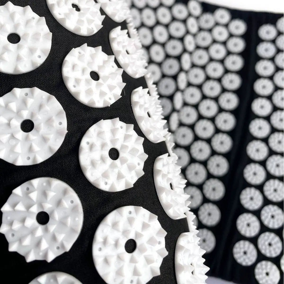 Drip Sweat Lotus Wellness Acupressure Mat with Pillow by Cavitation Machines; white circular studs on black surface