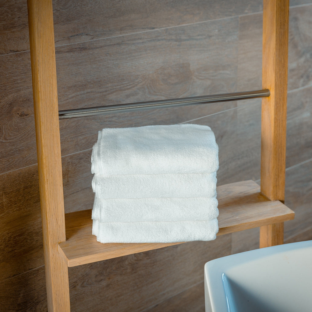 Luxury Organic Bath Mats four-pack on a wooden shelf with neatly folded white towels